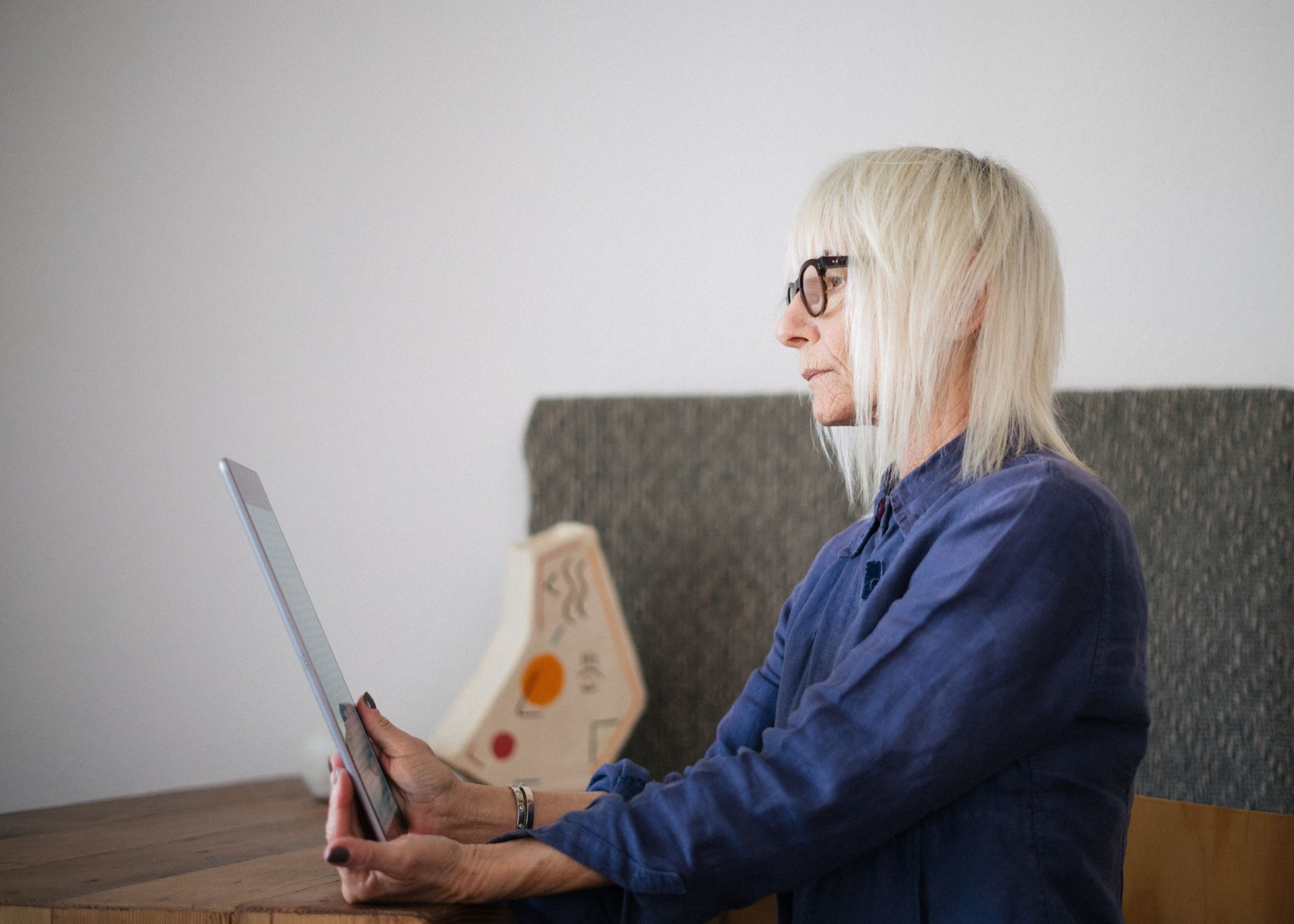 A reader with a tablet in a calm, sunlit room